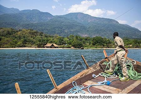 Stock Photograph - Tour boat approaches Mbali Mbali Mahale Lodge (Kungwe Beach Lodge) in Mahale Mountains National Park on the shores of Lake Tanganyika; Tanzania. Fotosearch