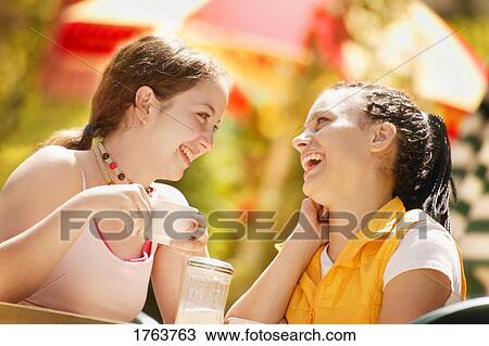 Two girls at a cafe View Large Photo Image Stock Image - Two girls at a cafe. Fotosearch