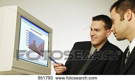 Stock Image - Two men working on computer. Fotosearch