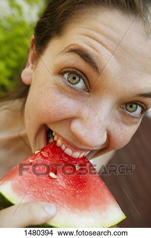 Picture - Woman eating watermelon. Fotosearch