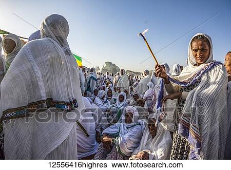 Stock Photograph - Woman holding a lit candle attending the Timkat ceremony during the Orthodox Tewahedo celebration of Epiphany, celebrated on January 19th; Arsi Negele, Oromia Region, Ethiopia. Fotosearch