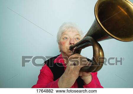 Stock Image - Woman plays horn. Fotosearch