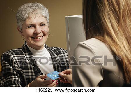 Stock Photography - Woman taking payment. Fotosearch