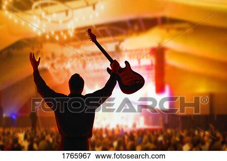 A man holds a guitar View Large Photo Image Stock Photo - A man holds a guitar. Fotosearch