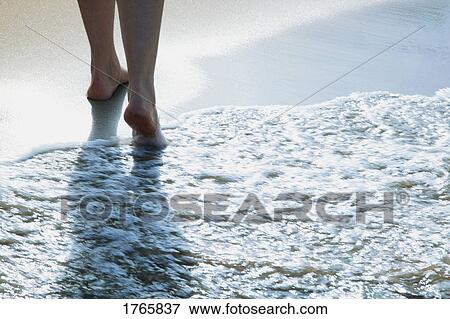 Stock Photo - A peaceful walk on the beach. Fotosearch