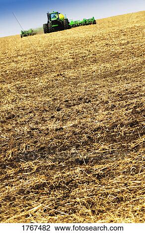 A tractor in a field View Large Photo Image Stock Image - A tractor in a field. Fotosearch