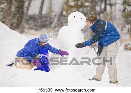 Stock Image - Building a snowman. Fotosearch