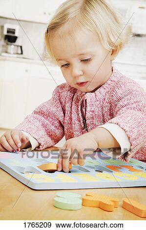 Stock Photo - Child plays in the kitchen. Fotosearch