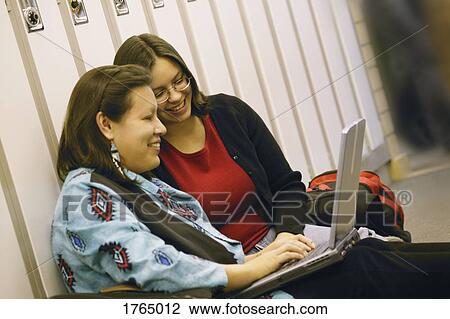 Two women work on lap top computer View Large Photo Image Stock Image - Two women work on lap top computer. Fotosearch