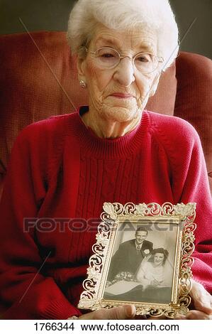 Woman holds a photo View Large Photo Image Picture - Woman holds a photo. Fotosearch