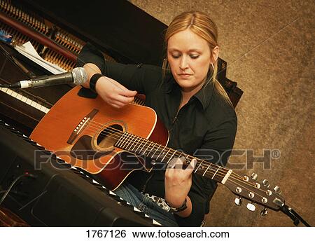 Stock Photograph - Woman plays guitar. Fotosearch