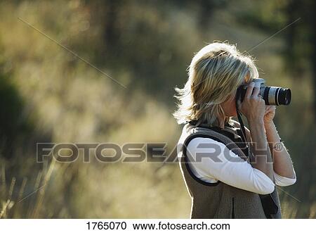 Stock Image - Woman takes photos. Fotosearch