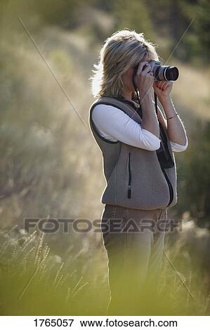 Stock Photo - Woman takes photos. Fotosearch