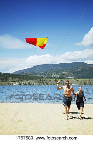 A couple fly a kite View Large Photo Image Stock Image - A couple fly a kite. Fotosearch
