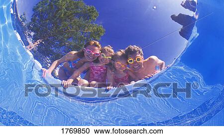 Stock Image - A family peering into a pool. Fotosearch
