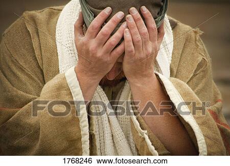 Stock Photograph - A man with hands over his face. Fotosearch