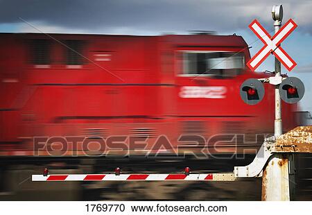 Stock Image - A train passing a railroad crossing. Fotosearch