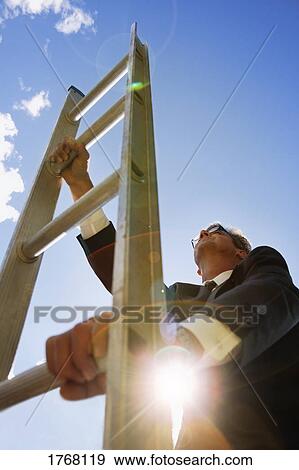 Businessman climbs the corporate ladder View Large Photo Image Stock Photo - Businessman climbs the corporate ladder. Fotosearch
