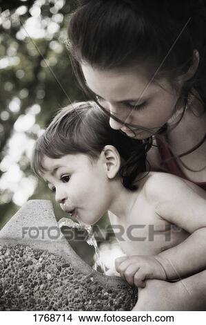 Picture - Child drinks from water fountain. Fotosearch