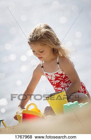 Stock Photo - Child playing in the sand. Fotosearch