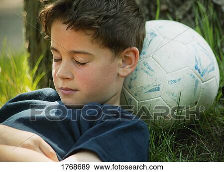 Child rests on soccer ball View Large Photo Image Stock Photo - Child rests on soccer ball. Fotosearch