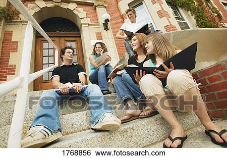 Stock Photograph - Classmates sit on steps at school. Fotosearch