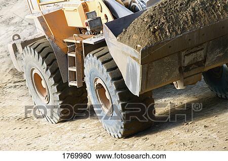 Close up of a tractor carrying dirt View Large Photo Image Stock Image - Close up of a tractor carrying dirt. Fotosearch