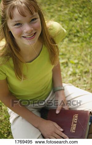 Girl holds a Bible View Large Photo Image Stock Photography - Girl holds a Bible. Fotosearch