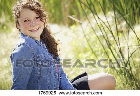 Girl posing in the grass View Large Photo Image Stock Photography - Girl posing in the grass. Fotosearch