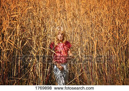 Stock Photo - Girl walking through a field. Fotosearch