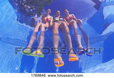 Girls dangling feet in pool View Large Photo Image Stock Photograph - Girls dangling feet in pool. Fotosearch