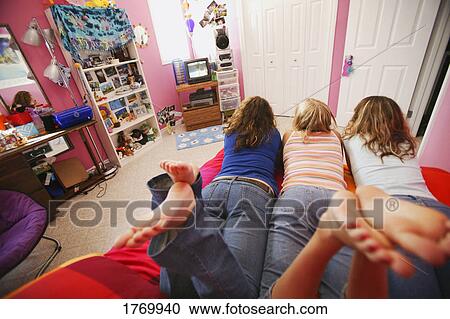 Stock Image - Girls hanging out in bedroom. Fotosearch