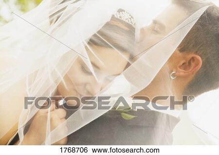 Stock Photograph - Groom kisses bride. Fotosearch