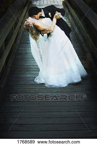 Stock Photo - Groom kisses bride's neck. Fotosearch