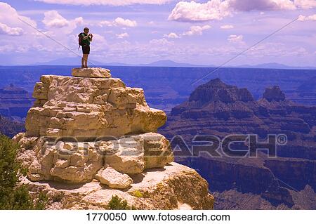 Man on top of rock formation View Large Photo Image Stock Image - Man on top of rock formation. Fotosearch