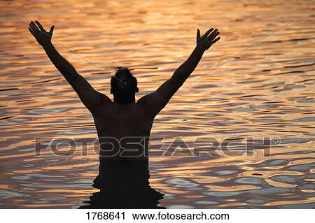 Man with arms raised in water View Large Photo Image Stock Image - Man with arms raised in water. Fotosearch