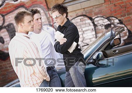 Stock Image - Men stand by sports car. Fotosearch