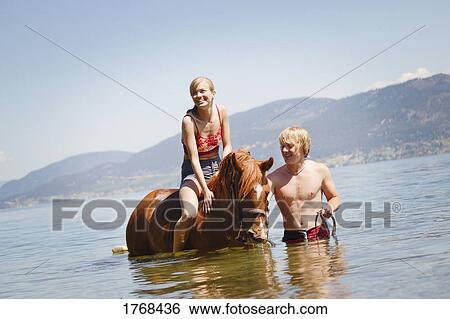 Stock Photograph - On horseback in the water. Fotosearch