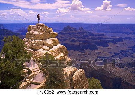 Stock Image - person on top of rock formation. Fotosearch