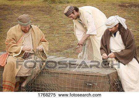Stock Photography - Three men working on a fishing net. Fotosearch