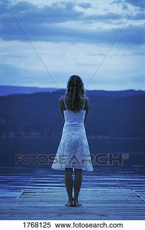Woman stands at the edge of a dock View Large Photo Image Stock Photography - Woman stands at the edge of a dock. Fotosearch