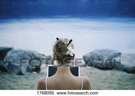 Stock Photography - Woman works on lap top computer at the lake. Fotosearch