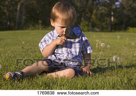Stock Photo - Young boy with magnifying glass. Fotosearch