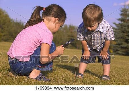 Young children with magnifying glass View Large Photo Image Picture - Young children with magnifying glass. Fotosearch
