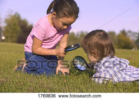 Young children with magnifying glass View Large Photo Image Stock Photograph - Young children with magnifying glass. Fotosearch