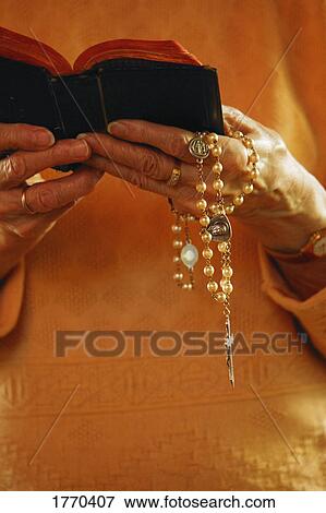 Bible & rosary beads held View Large Photo Image Stock Photo - Bible & rosary beads held. Fotosearch