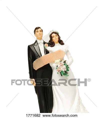 Stock Image - Bride and groom ornament with Band-Aid on them. Fotosearch