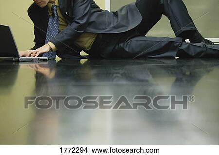 Picture - Businessman working on laptop. Fotosearch