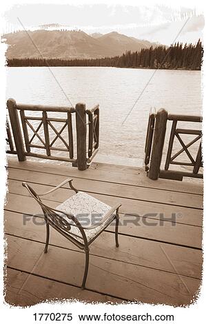 Chair on a deck overlooking a lake View Large Photo Image Stock Photography - Chair on a deck overlooking a lake. Fotosearch