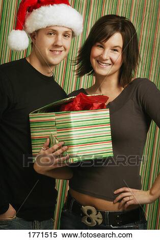 Stock Photography - Couple holding Christmas present. Fotosearch